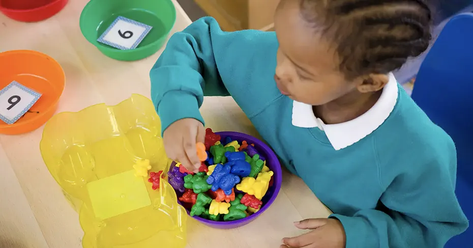 NALDIC's Mission Statement - Young girl using coloured toys to count