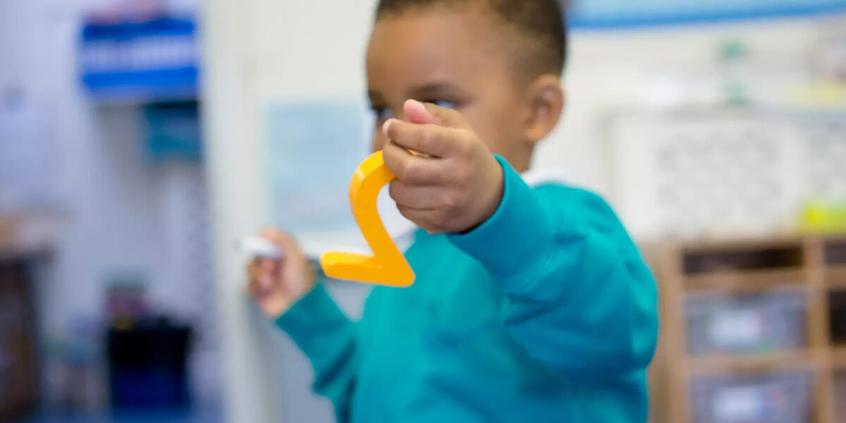 Young boy holding a plastic number in his hand