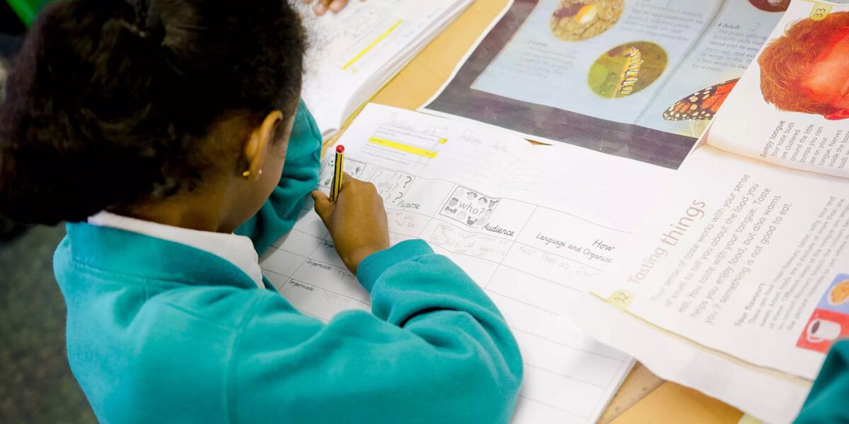 NALDIC Eventbrite Image - Girl writing on a sheet of paper in a class lesson